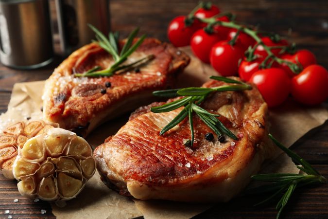 Composition with fried steaks on wooden background. Grilled food