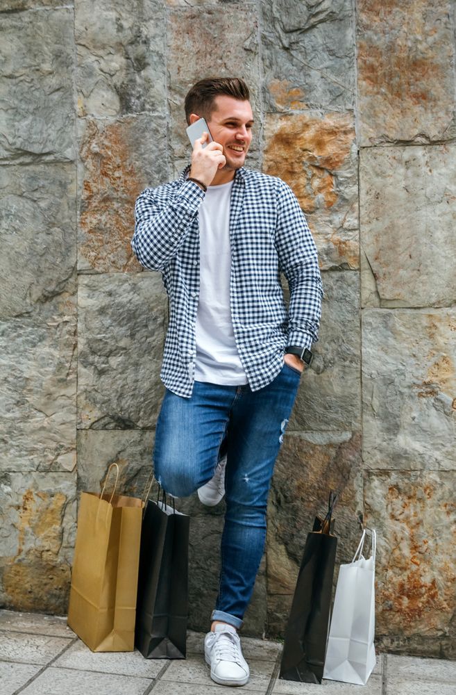 Young man with shopping bags and mobile