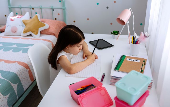 Girl doing homework in her bedroom