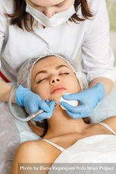 Woman having facial beauty treatment with instrument on her chin 5aVjo4