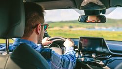 Young man holding steering driving