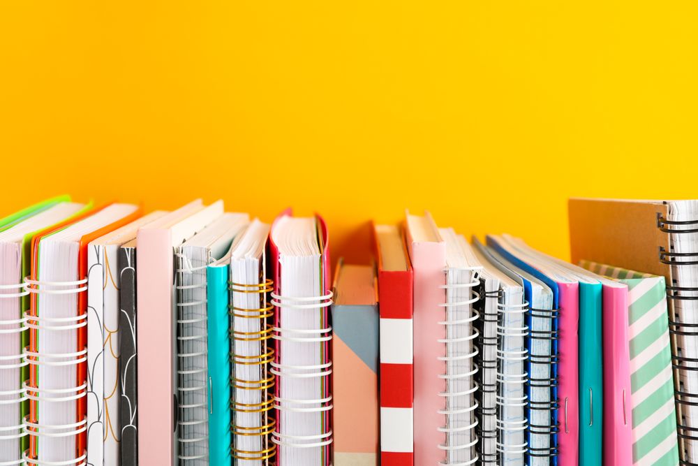 Stack of colorful books against background, space for text