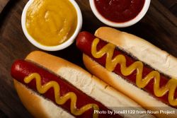 Top view close up of two hot dogs with mustard 56jVV5