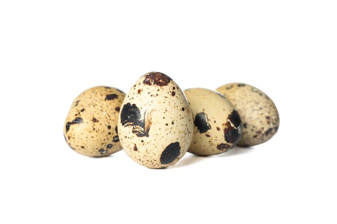 Few raw quail eggs on plain background