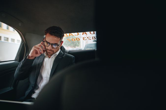 Businessman managing office work on the move sitting in a cab