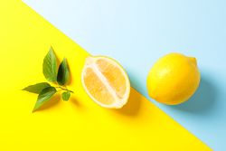 Flat lay composition with lemons on two tone background, space for text