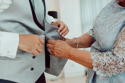 Woman buttoning up man waistcoat