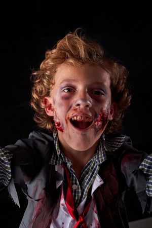 Vertical photo of a boy disguised as a zombie with an expression of having fun