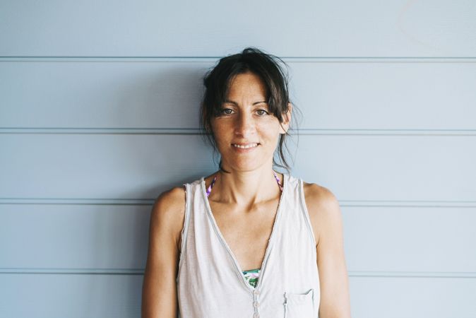 Portrait of woman with ponytail leaning on wood wall