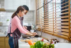 Couple cleaning together at the kitchen sink