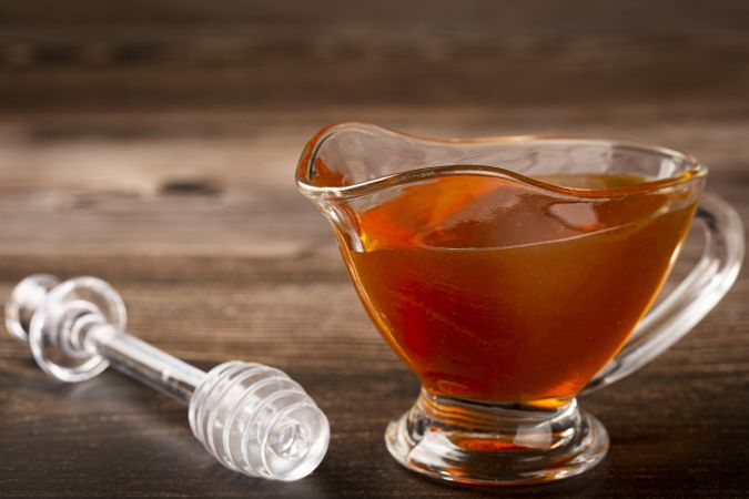 Honey in glass bowl on the table.