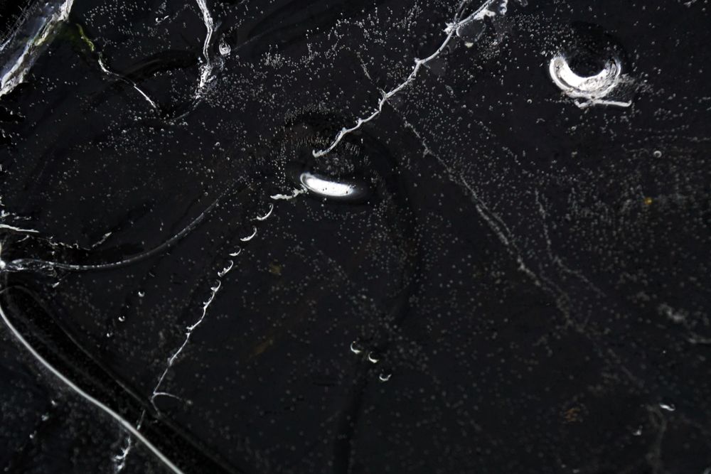 Fragment of thin ice on dark frozen river