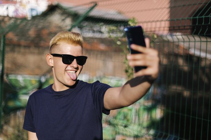Male with sunglasses taking a selfie outdoors