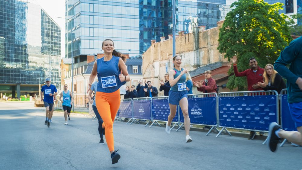Diverse Group of People Running a Marathon in a City During the Day.