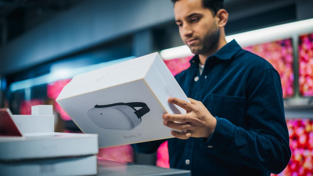 Young Man Shopping for a Virtual Reality System in a Home Electronics Store.