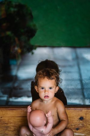 small girl playing with baby doll