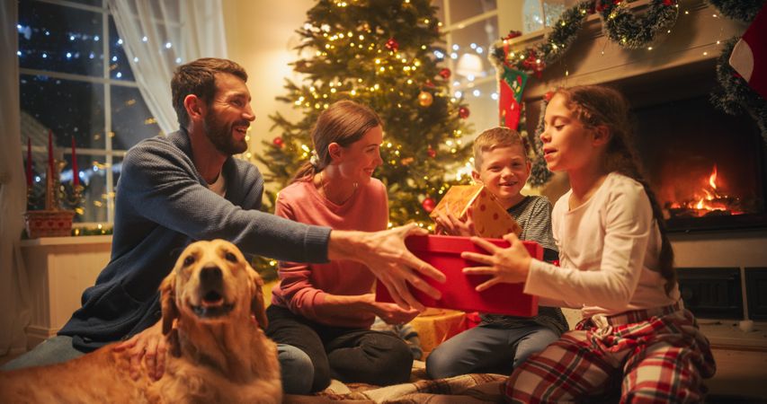 Loving Young Parents Giving Gifts to Their Children on Christmas Eve.
