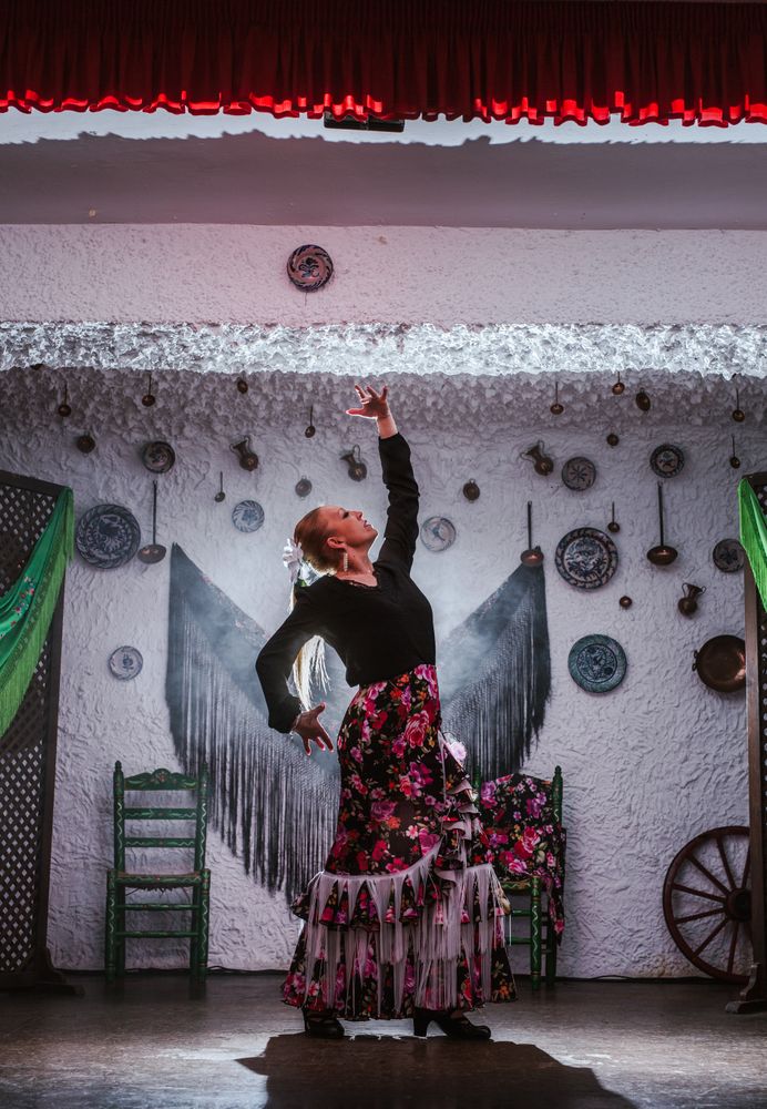 Woman dancer in flamenco costume standing in dance posture