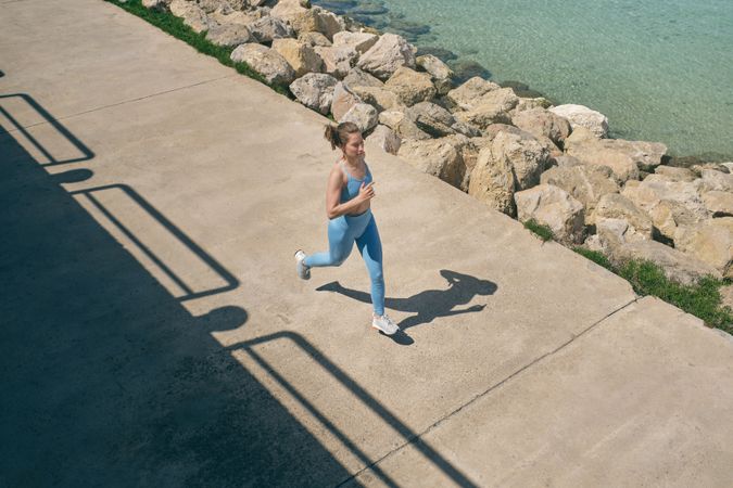 Active runner jogging on embankment during workout