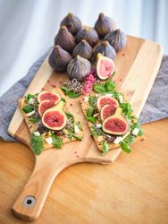 Served food along with uncut fresh figs on wooden tray