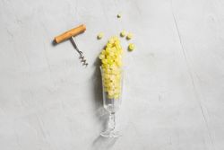 Wineglass filed with grapes on gray background