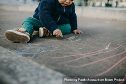A toddler playing with chalk 5o6Xg0