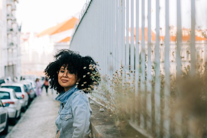 Happy Black female by metal fence