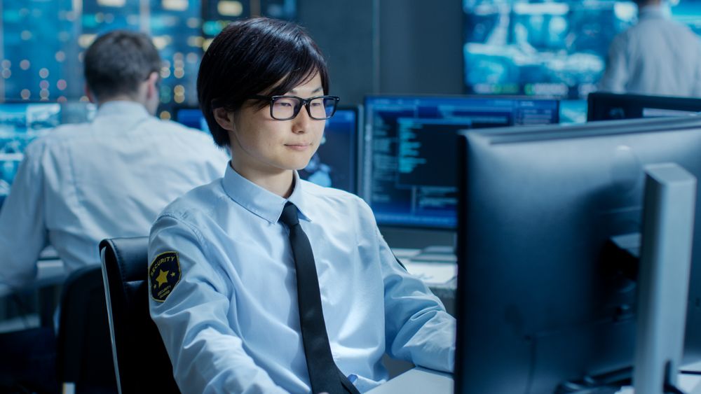 In the Security Command Center Officer at His Workstation Monitors Multiple Screens for Unlawful Infiltration.