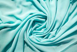 Spiral Twisted Turquoise wavy crumpled fabric with little sparkling dust, texture and  background.