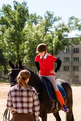 Smiling young rider on horse outdoors.