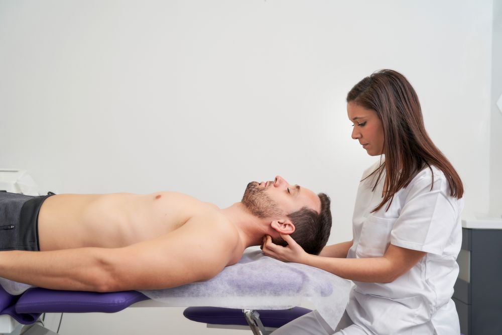 a man receiving migraine treatment at the physiotherapist's office