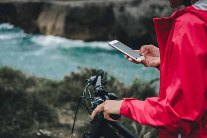 Anonymous female bicyclist using smartphone