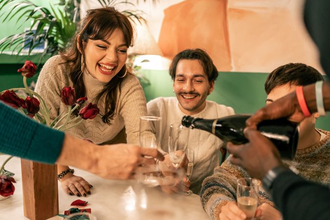 Diverse group of friends laughing together at a joyful Christmas celebration.