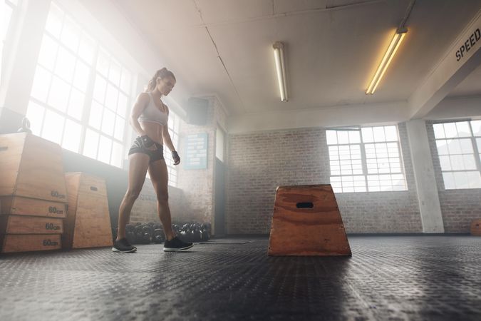 Shot of a muscular young woman working out with a box at the gym