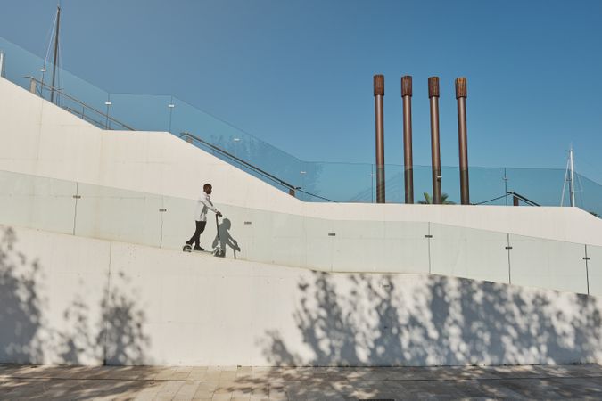Black man riding scooter on ramp