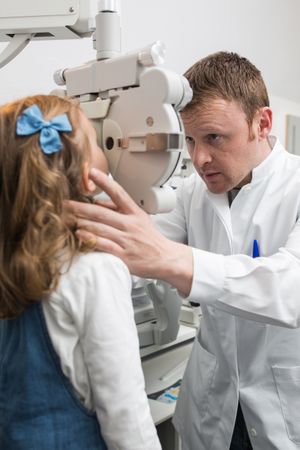 Optician testing a girl's eyes