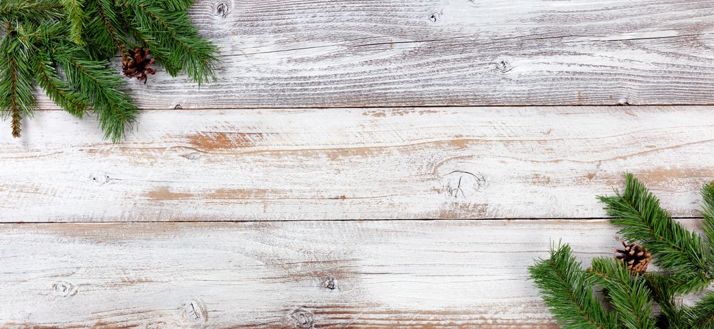Christmas Evergreen decorations in left and right corners on vintage wooden boards