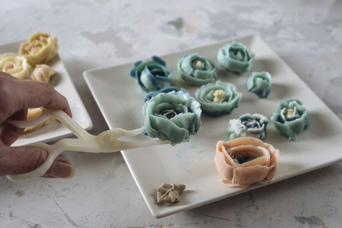 Hand holding buttercream flower