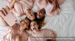 Top view of bride taking selfie with bridesmaids making funny faces 5rXoMb