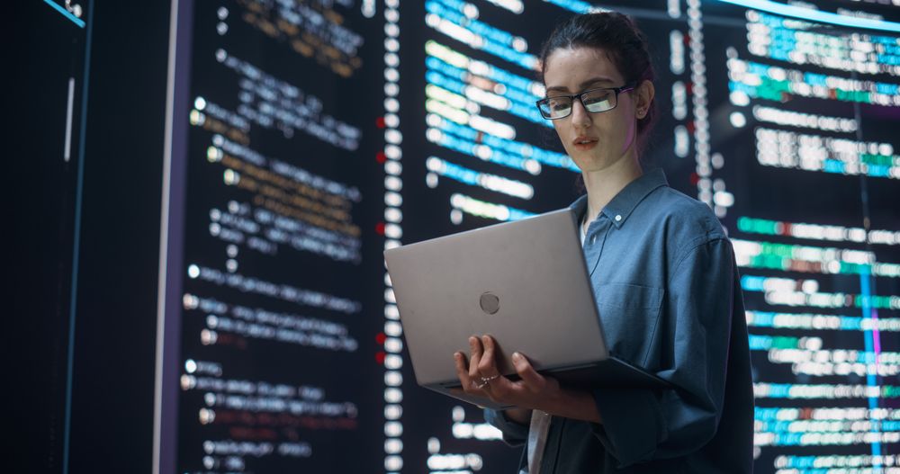 Portrait of Woman Creating a Software and Coding, Surrounded by Big Screens Displaying Lines of Programming Language Code.