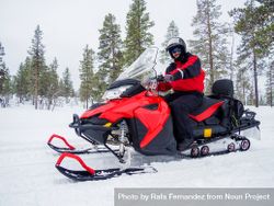 Happy smiling man driving snowmobile in Finnish Lapland 48KKY5