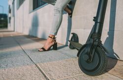 Electric scooter in the street and woman in background.
