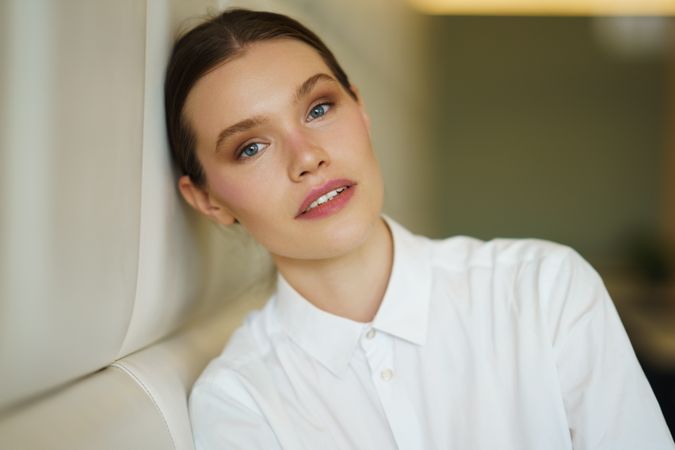 Woman leaning against beige wall