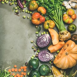 Seasonal fall vegetables, squash, carrots, tomatoes, on concrete background, copy space, square crop