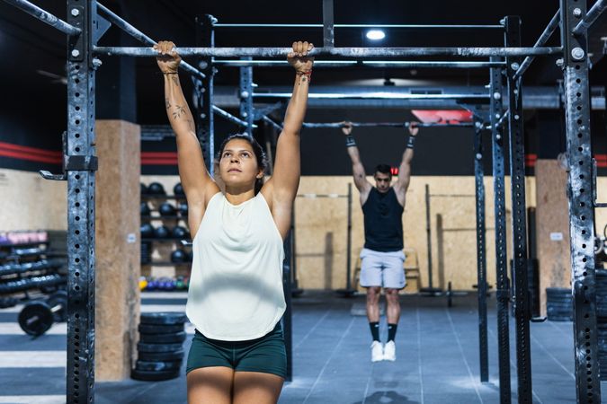 Sportive couple hanging on crossbars