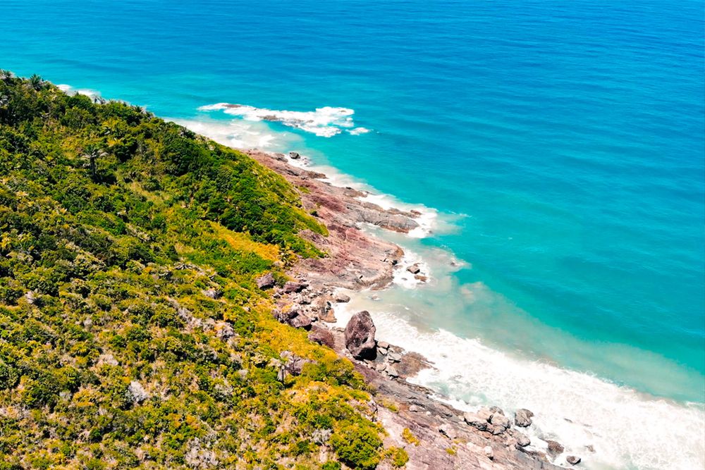 Green grass covered hill beside blue sea