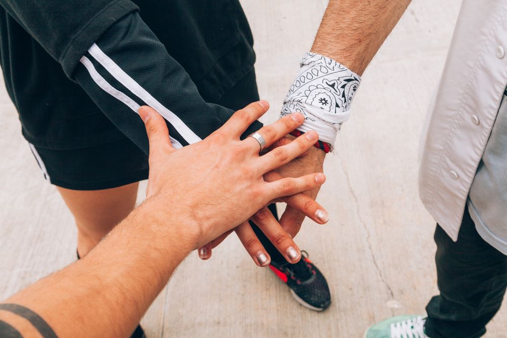 Group of young people putting hands together