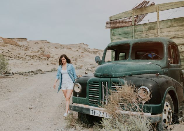 Relaxed female walking by old truck
