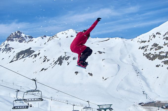 Unrecognizable snowboarder jumping on slope