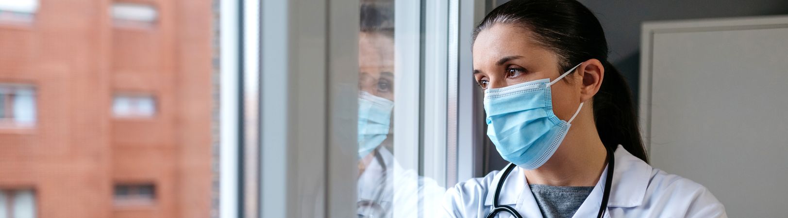 Female doctor looking out the hospital window